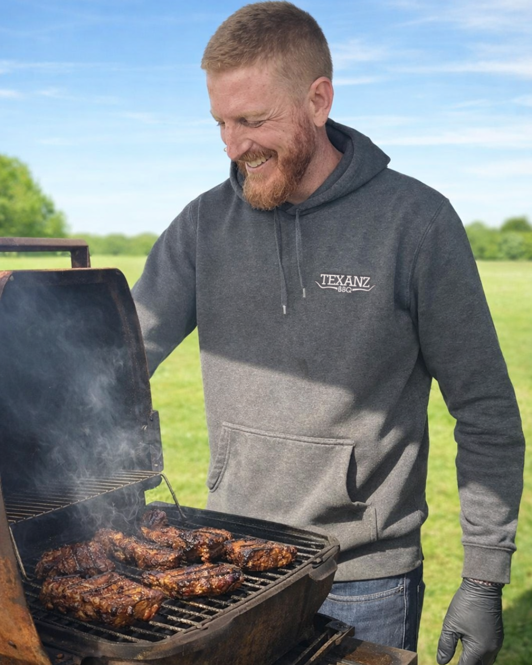 man cooking BBQ meat with Texanz hoodie